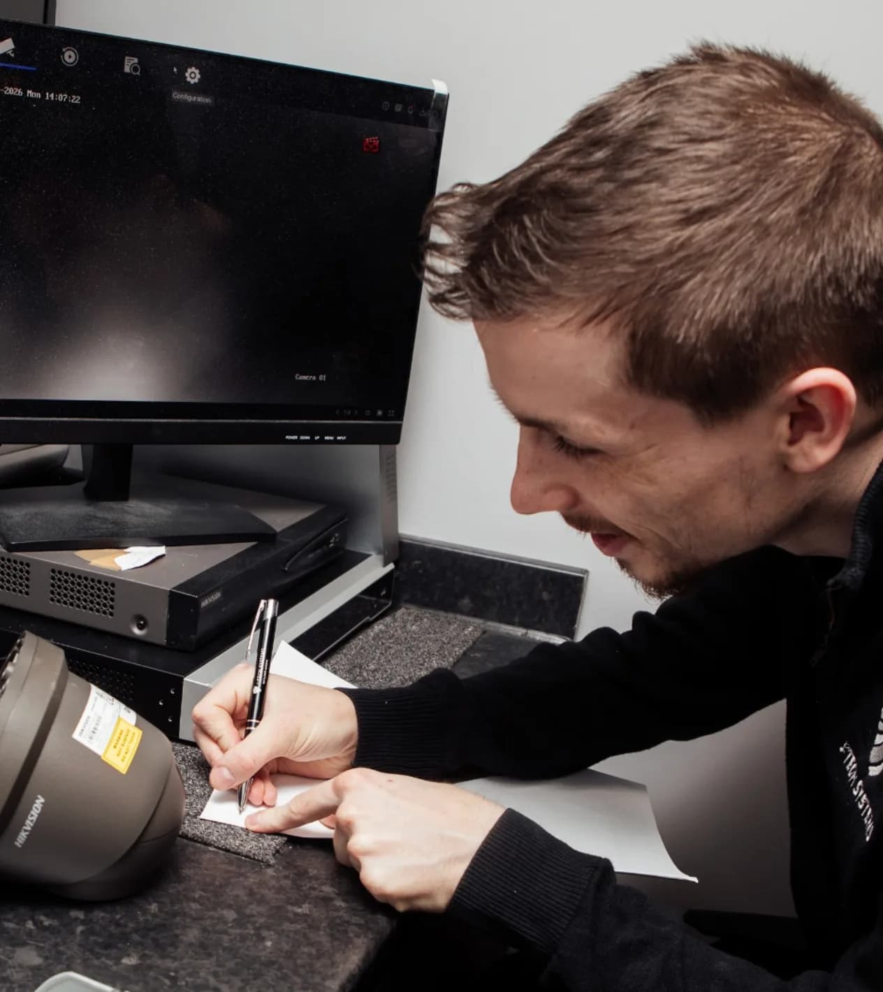A J-Tech engineer checking a CCTV camera against its live feed