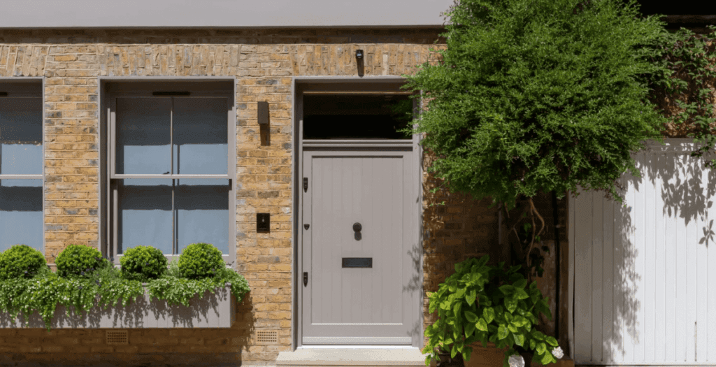 A front door with a discreet video door entry and access control panel beside it